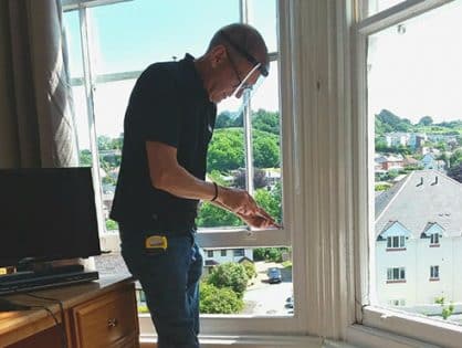 man repairing sash window