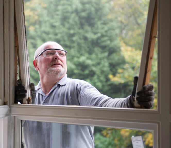 man repairing window
