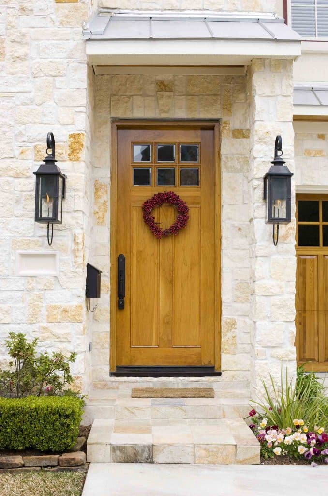 white stone porch entrance with golden oak composite front door
